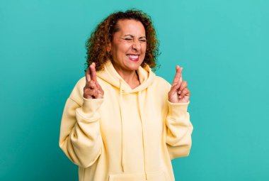 Orta yaşlı İspanyol kadın gergin ve umutlu, şans diliyor ve dua ediyor.