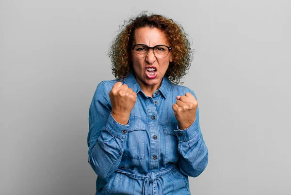 中年のヒスパニック系の女性が積極的にイライラし 怒りの表情とタイトな拳で叫んで 激怒感 — ストック写真