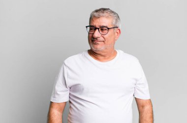 Orta yaşlı adam merak ediyor, mutlu düşünceler ve fikirler düşünüyor, hayal kuruyor, kenarda yer arıyor.