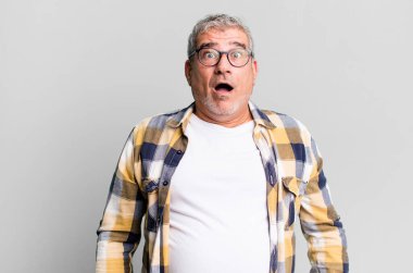 Orta yaşlı bir adam şok olmuş ya da şaşırmış görünüyor, ağzı açık bir şekilde 