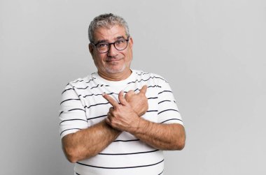 Orta yaşlı, kafası karışmış, güvensiz ve zıt yönlere şüpheyle bakan bir adam.