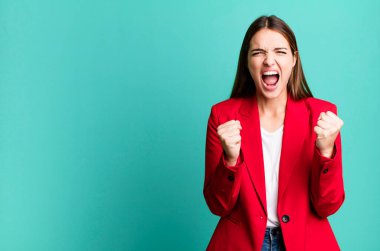 Genç ve güzel bir kadın sinirli bir ifadeyle agresif bir şekilde bağırıyor. İş kadını kavramı