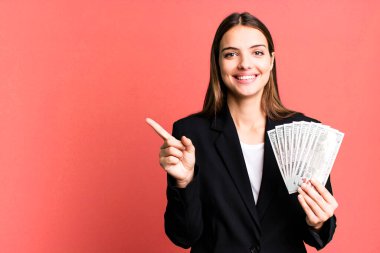 Genç ve güzel bir kadın heyecanlı ve şaşırmış görünüyor. iş ve dolar banknotları kavramı