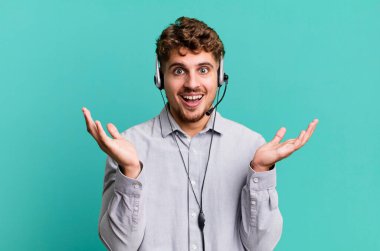 Genç, beyaz bir adam kendini mutlu hissediyor ve inanılmaz bir şeye hayret ediyor. tele pazarlamacı ajan konsepti