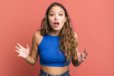 Genç, güzel bir kadın şok olmuş ve hayrete düşmüş görünüyor. İnanılmaz bir şey fark ettiğinde ağzı açık kalmış.