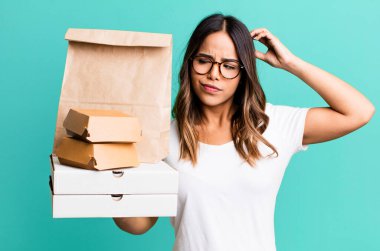 İspanyol güzel kadın şaşkın ve kafası karışık, kaşınan bir kafa hissediyor. Fast food konseptini götür.