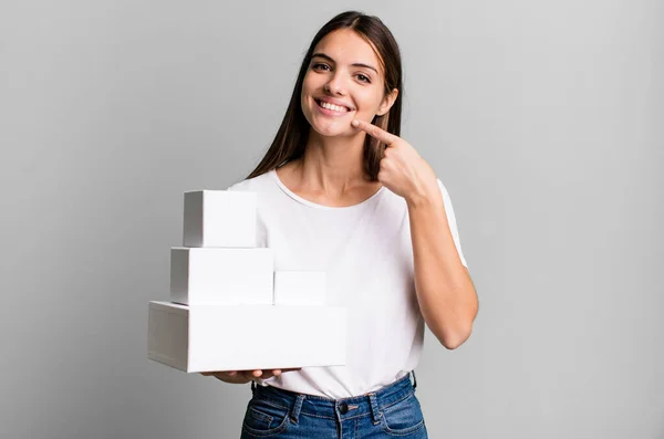 自信を持って笑顔で笑顔を見せる若い女性 白い箱 — ストック写真