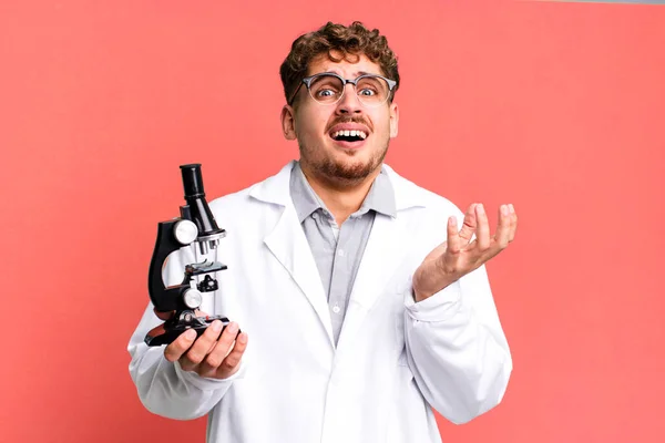 若い大人の白人男性は絶望的でフラストレーションを感じストレスを感じていました 顕微鏡の概念を持つ科学研究室の学生は — ストック写真