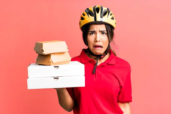 stock image hispanic pretty woman feeling sad and whiney with an unhappy look and crying.  delivery woman and take away concept