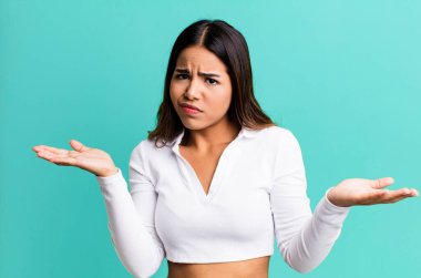 İspanyol güzel kadın şaşkın, şaşkın ve stresli görünüyor, farklı seçenekler arasında merak ediyor, kararsız hissediyor