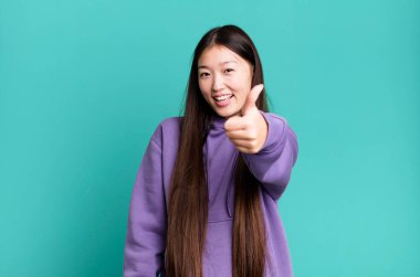 Genç, güzel, Asyalı, etkileyici bir kadın. Yanında fotokopi odası var.