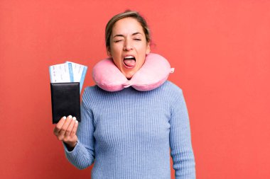 Güzel, sarışın, neşeli ve asi tavırlı, şaka yapan ve dilini dışarı çıkaran bir kadın. uçuş yolcu kavramı