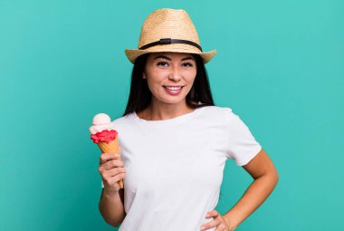 İspanyol güzel kadın mutlu bir şekilde gülümsüyor, eli kalçasında ve kendinden emin. dondurma ve yaz konsepti