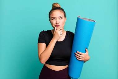 Hispanik güzel kadın düşünüyor, kuşkulu ve şaşkın hissediyor. fitness ve yoga konsepti