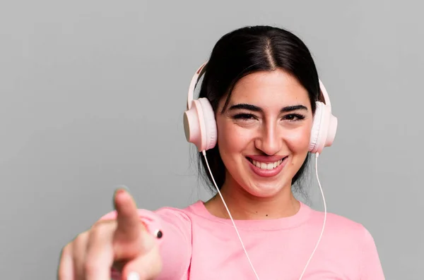 stock image pointing at camera choosing you. listening music with headphones