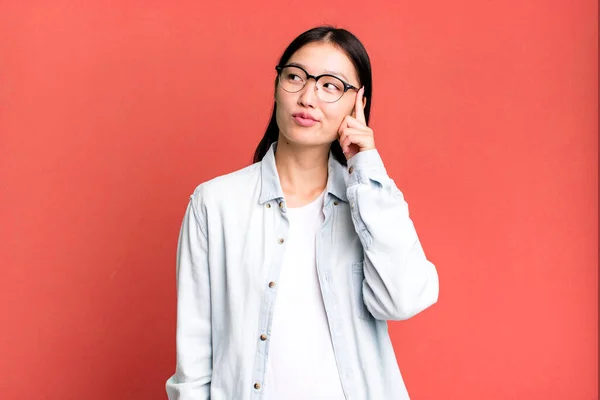 stock image young adult pretty asian expressive woman with a copy space to the side