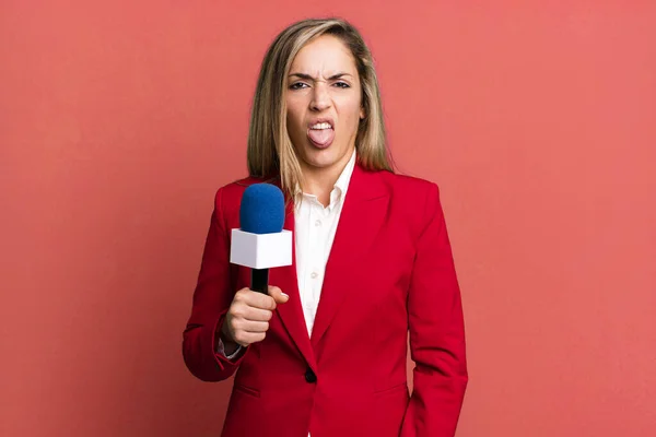 stock image pretty blonde woman feeling disgusted and irritated and tongue out. presenter with a microphone concept