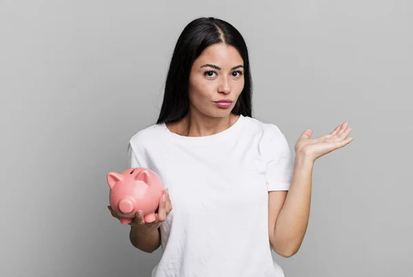 Hispanic Pretty Woman Feeling Puzzled Confused Doubting Piggy Bank — Stock Photo, Image