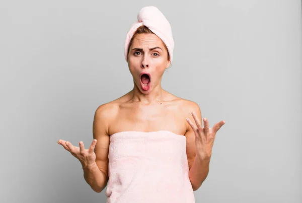 stock image hispanic pretty woman amazed, shocked and astonished with an unbelievable surprise wearing pbathrobe. beauty concept