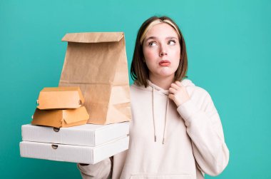 Genç ve güzel bir kadın stresli, endişeli, yorgun ve hayal kırıklığına uğramış hissediyor. Fast food konseptini kaldır.