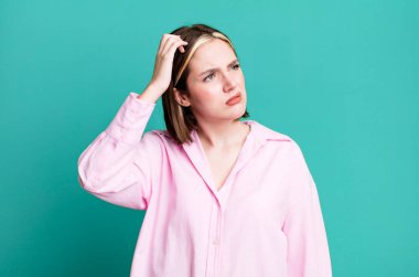 Kafası karışmış, kafası karışmış, kaşınan genç bir kadın.