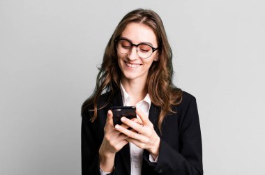 Genç ve güzel bir kadın akıllı telefon kullanıyor. 