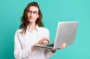 Bilgisayarı olan genç ve güzel bir iş kadını.