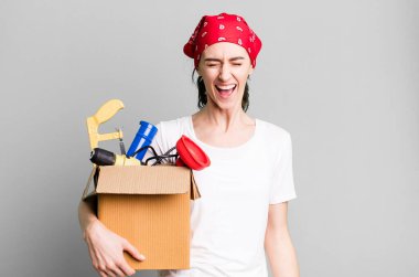 Genç ve güzel bir kadın agresif bir şekilde bağırıyor, çok kızgın görünüyor. kahya ve alet çantası kavramı