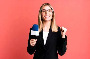 Genç ve güzel bir kadın şokta, gülüyor ve başarıyı kutluyor. sunucu veya gazeteci kavramı