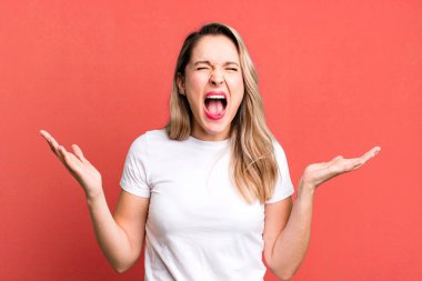 Öfkeyle bağırıyor, stresli hissediyor ve ellerini havaya kaldırıp 