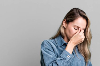 Stresli, mutsuz ve hayal kırıklığına uğramış hissediyorum. Alnıma dokunuyor ve şiddetli baş ağrısı çekiyorum.