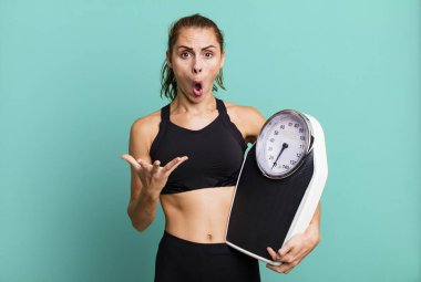 İspanyol güzel kadın inanılmaz bir sürprizle şaşkın, şaşkın ve şaşkın. fitness, diyet ve ağırlık ölçeği kavramı