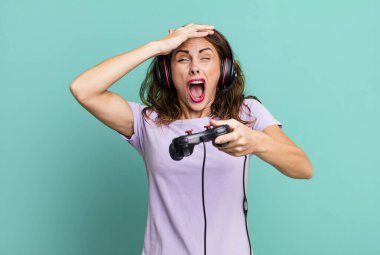 hispanic pretty young woman playing with headphones and a control. gamer concept