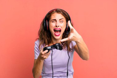 hispanic pretty young woman playing with headphones and a control. gamer concept