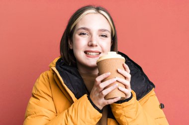 young pretty woman with a coat and a take away coffee