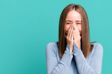 Mutlu, neşeli, şanslı ve şaşkın görünüyor iki eliyle ağzını kapatıyor.