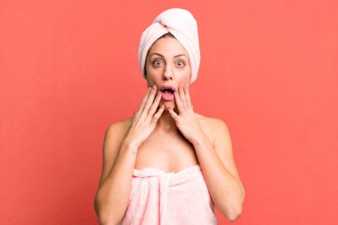 Güzel sarışın kadın şok olmuş ve korkmuş hissediyor. Bornoz ve güzellik konsepti