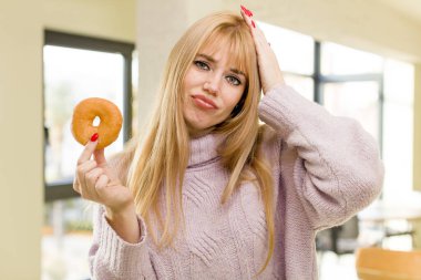 Donutlu genç ve güzel bir kadın. İç mekanda sağlıksız diyet kavramı