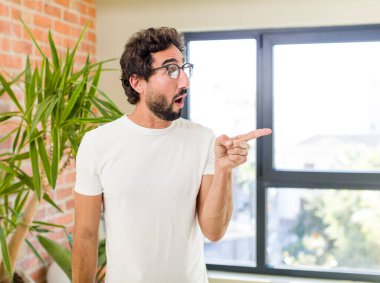 young adult crazy man with expressive pose at a modern house interior