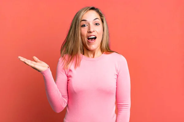 Blonde Adult Woman Looking Surprised Shocked Jaw Dropped Holding Object — Stockfoto