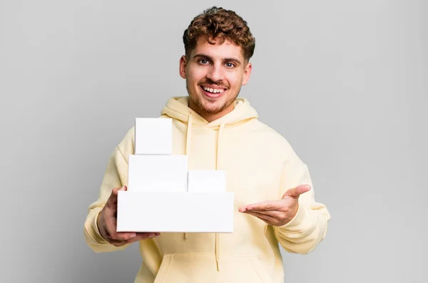 若い大人の白人男性は陽気に笑って幸せを感じコンセプトを示しています 異なるパッケージのコンセプトを — ストック写真