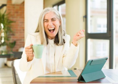 Yaşlı, güzel bir kadın kızgın, sinirli ve dokunmatik ekranla hayal kırıklığına uğramış görünüyor.