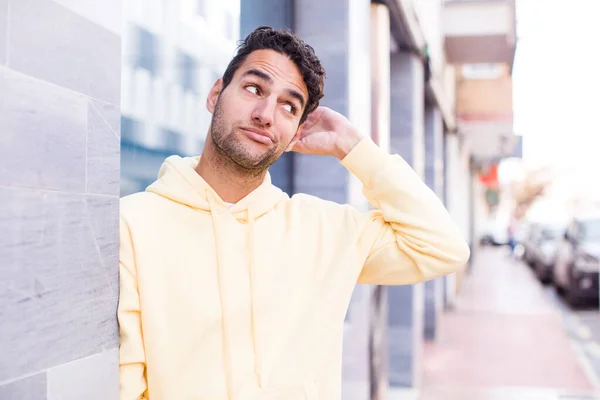 Young Hispanic Man Feeling Puzzled Confused Scratching Head Looking Side — Stock Photo, Image