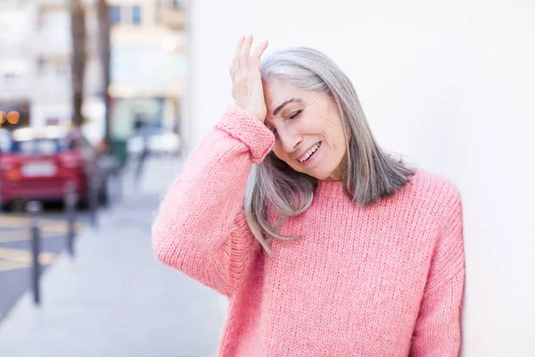 年长的退休漂亮的白发女人笑着拍拍额头像在说啊 我忘了 不然就是个愚蠢的错误 — 图库照片