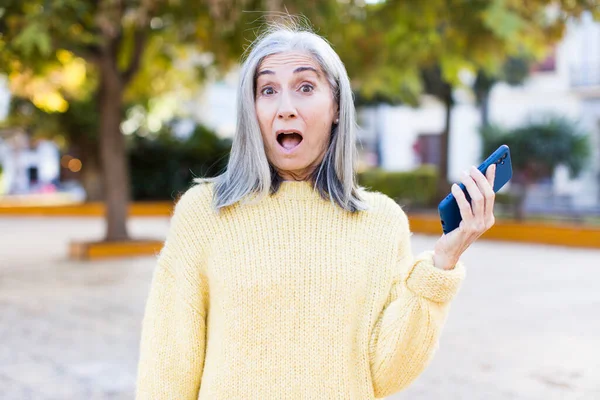 Όμορφη Ηλικιωμένη Γυναίκα Αισθάνεται Εξαιρετικά Σοκαρισμένος Και Έκπληκτος Ένα Smartphone — Φωτογραφία Αρχείου