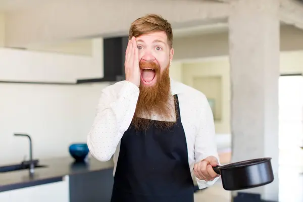 赤い髪の男はキッチンで信じられないほどの何かに幸せと驚きを感じている シェフのコンセプト — ストック写真