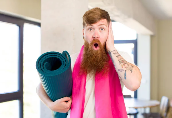 红头发的男人对瑜伽垫感到非常震惊和惊讶 健身概念 — 图库照片