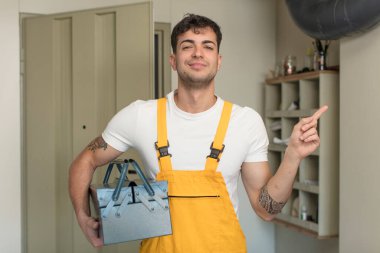 Genç yakışıklı adam neşeyle gülümsüyor, mutlu hissediyor ve bir tarafı işaret ediyor. Becerikli adam kavramı