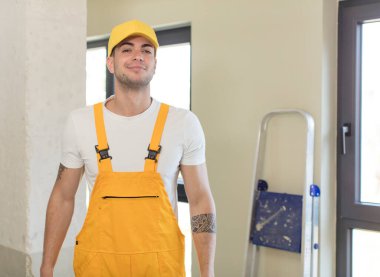 Genç ve yakışıklı bir adam gülümsüyor ve kendine güveni tam bir ifadeyle bakıyor. Becerikli adam kavramı