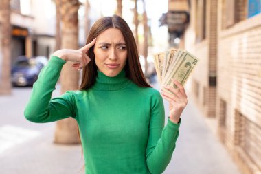 Şaşırmış görünüyor, yeni bir düşünce, fikir ya da konseptin farkına varıyor. Dolar banknotları konsepti